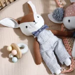 Knuffel van een bambi jongetje. Popje heeft een blauw rompertje aan.